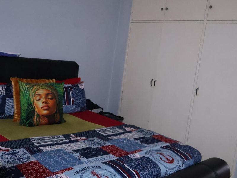 A bedroom featuring built-in cupboards with overhead storage compartments.