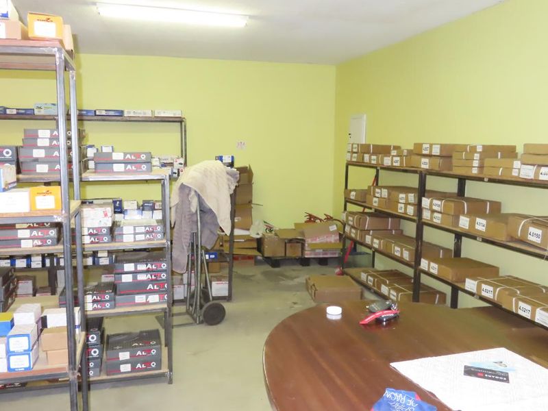 A functional utility or storage room featuring extensive metal shelving units for organized inventory management and overhead fluorescent lighting.