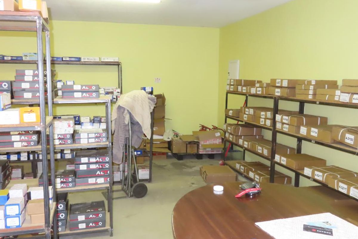 A functional utility or storage room featuring extensive metal shelving units for organized inventory management and overhead fluorescent lighting.