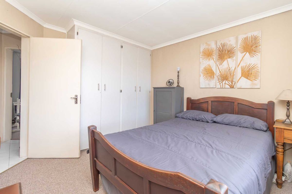 A bedroom featuring built-in cupboards and neutral wall finishes, providing a functional and comfortable living space.
