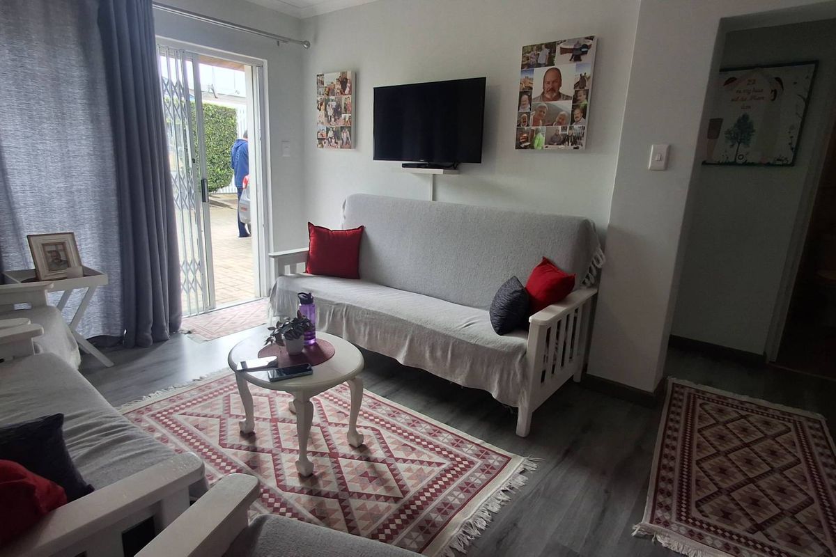 A comfortable living room featuring laminate flooring and a sliding glass door that provides direct access to the outdoor area.