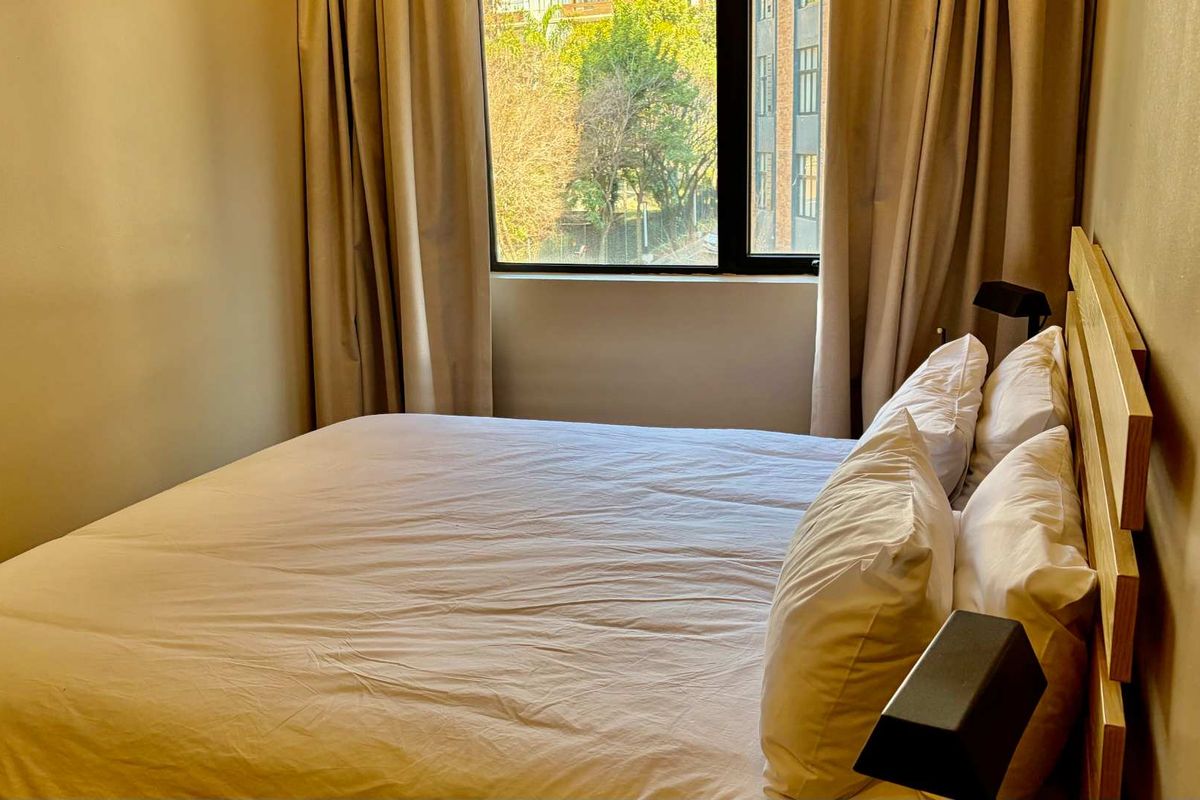 A cozy bedroom featuring a large window that allows for natural light, creating a bright and inviting atmosphere.