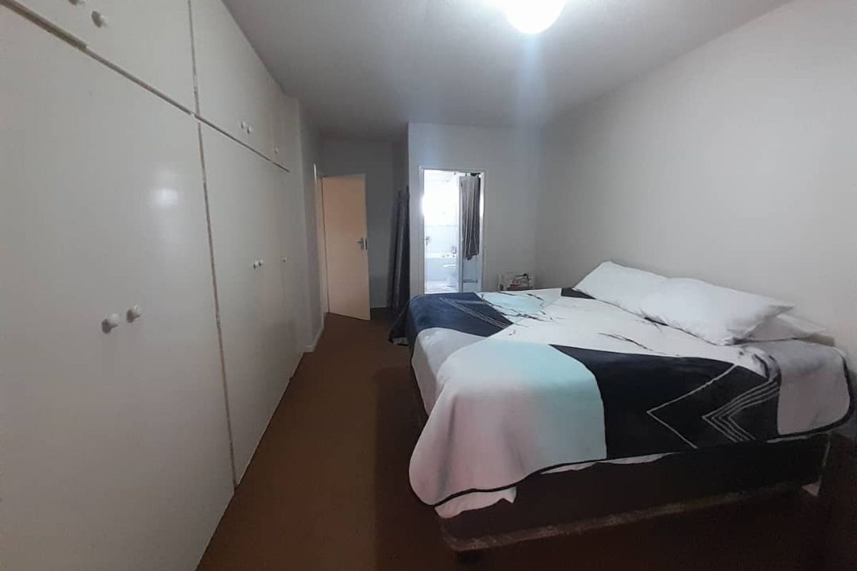 A bedroom featuring built-in floor-to-ceiling cupboards and direct access to an en-suite bathroom.