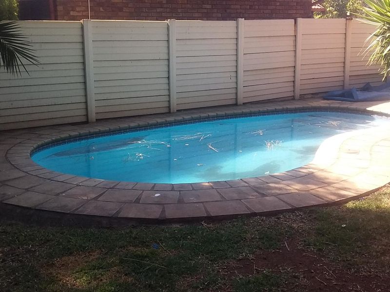 A private swimming pool area featuring a paved surround and enclosed by a boundary fence, offering a dedicated space for outdoor recreation.