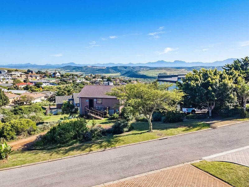 Elevated view overlooking the residential neighbourhood, surrounding landscape, and distant mountain range.