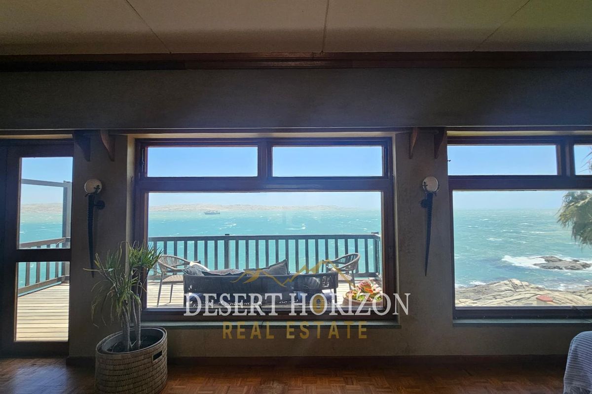 Living area featuring large windows with expansive ocean views and direct access to an outdoor deck.