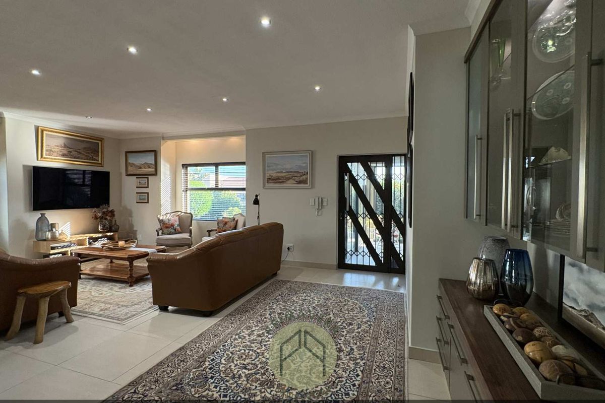 Spacious open-plan living area featuring tiled floors, recessed downlighting, and custom built-in cabinetry, providing a bright and functional space.