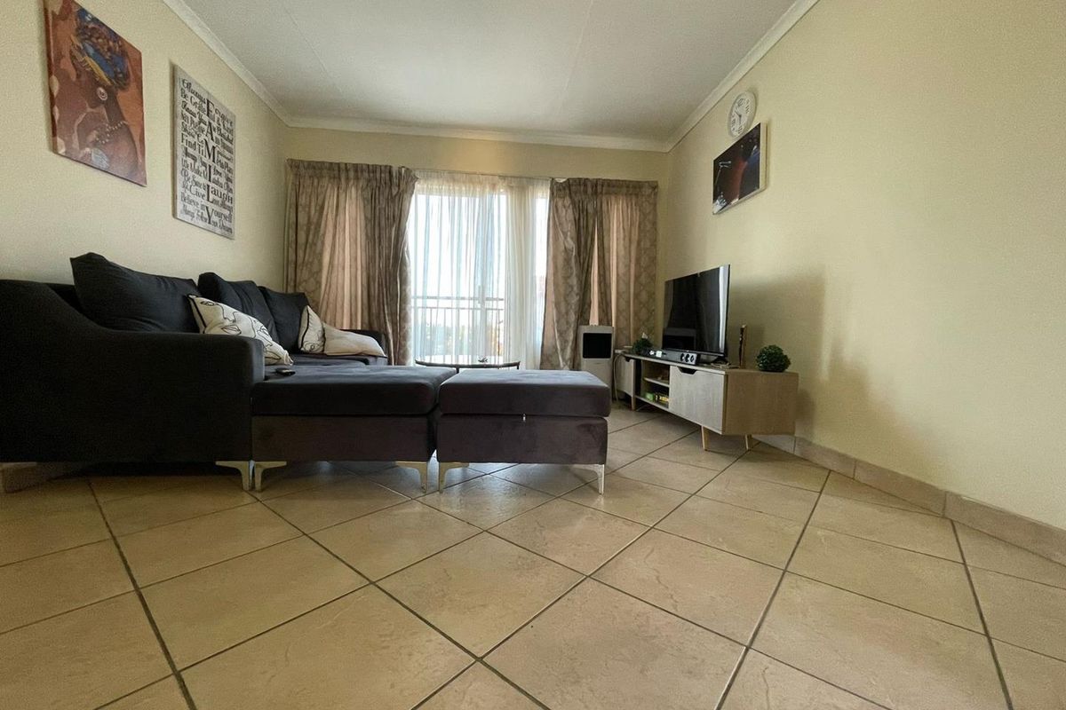 A comfortable living room featuring tiled flooring and a sliding glass door providing access to an outdoor area.