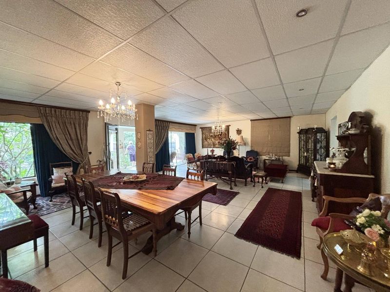 Spacious open-plan living and dining area featuring tiled flooring, recessed lighting, and large sliding glass doors leading to the outdoor space.