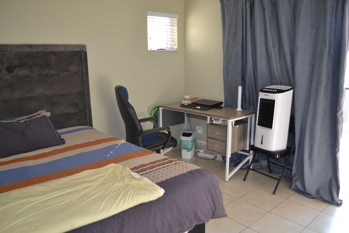 A functional bedroom featuring tiled flooring and a window, providing a neutral space ready for personalization.