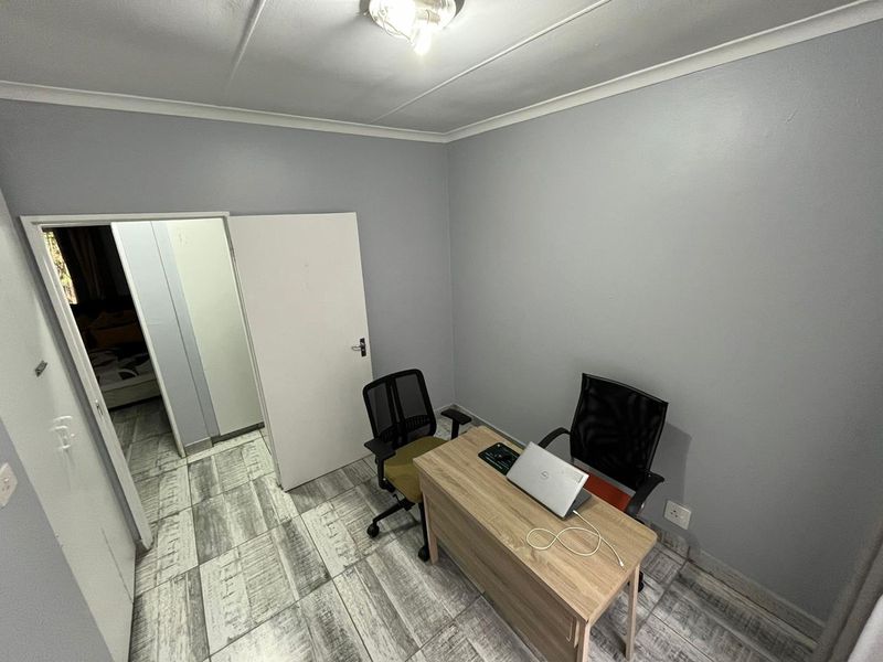 A functional office space featuring tiled flooring and neutral wall finishes, suitable for a home workspace or study area.