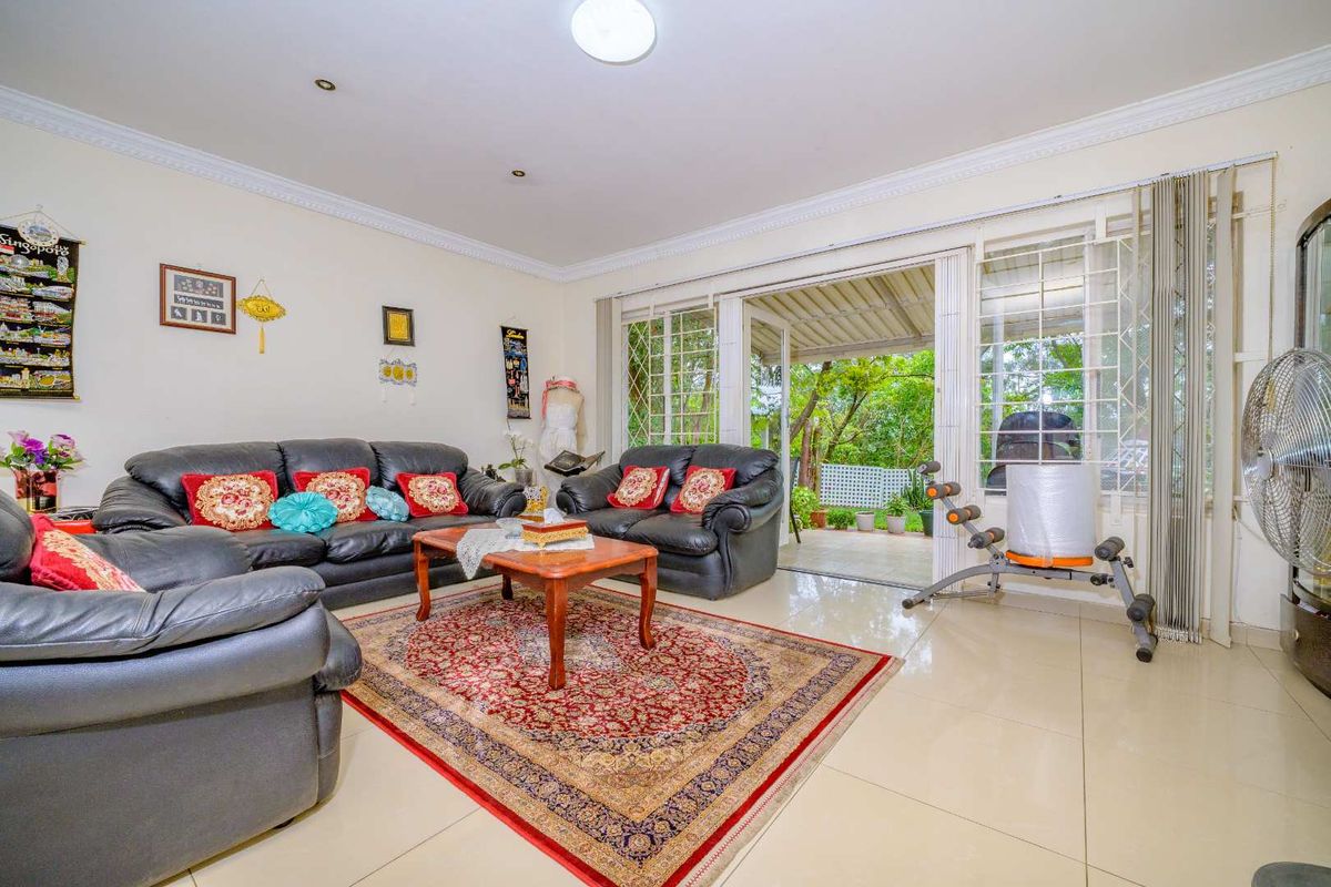 Spacious living room featuring tiled flooring, recessed lighting, and large sliding glass doors providing direct access to the outdoor patio area.