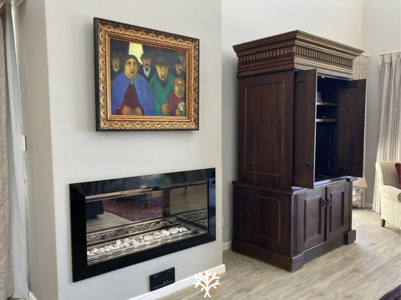 A well-maintained living room featuring a modern built-in fireplace with a sleek black frame and light-toned laminate flooring.