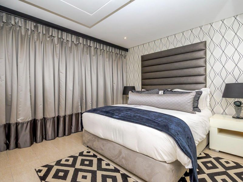 A well-maintained bedroom featuring tiled flooring, recessed ceiling lighting, and decorative patterned wallpaper with a modern aesthetic.