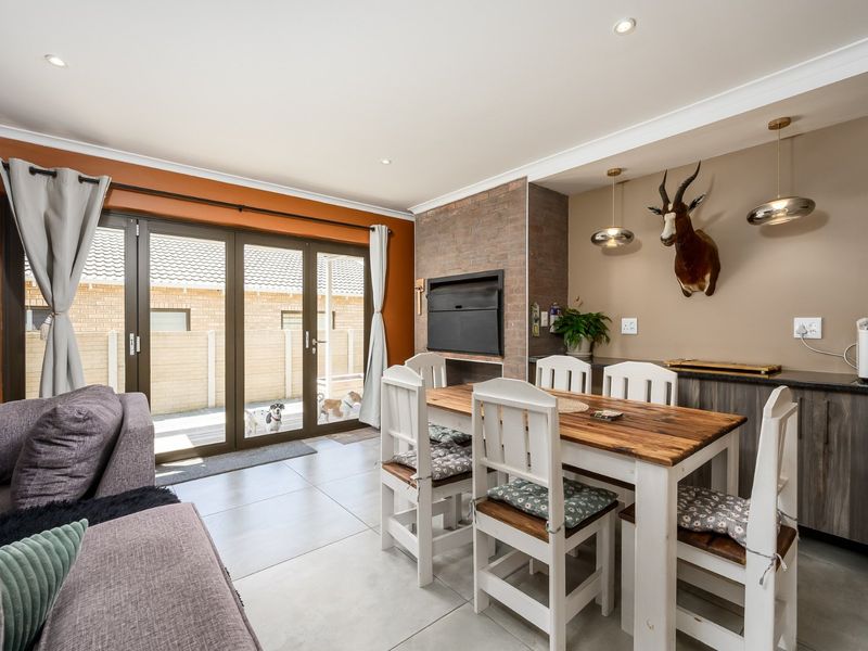 Open plan living and dining area featuring a built-in brick fireplace, tiled flooring, and sliding glass doors leading to the exterior.