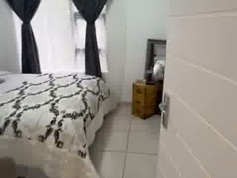 A bedroom featuring tiled flooring and a modern horizontal panel door, viewed from the doorway.
