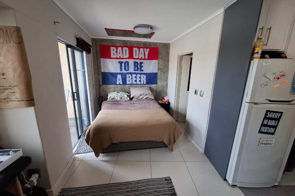 Compact bedroom featuring tiled flooring, built-in cabinetry, and a sliding glass door providing access to an outdoor area.
