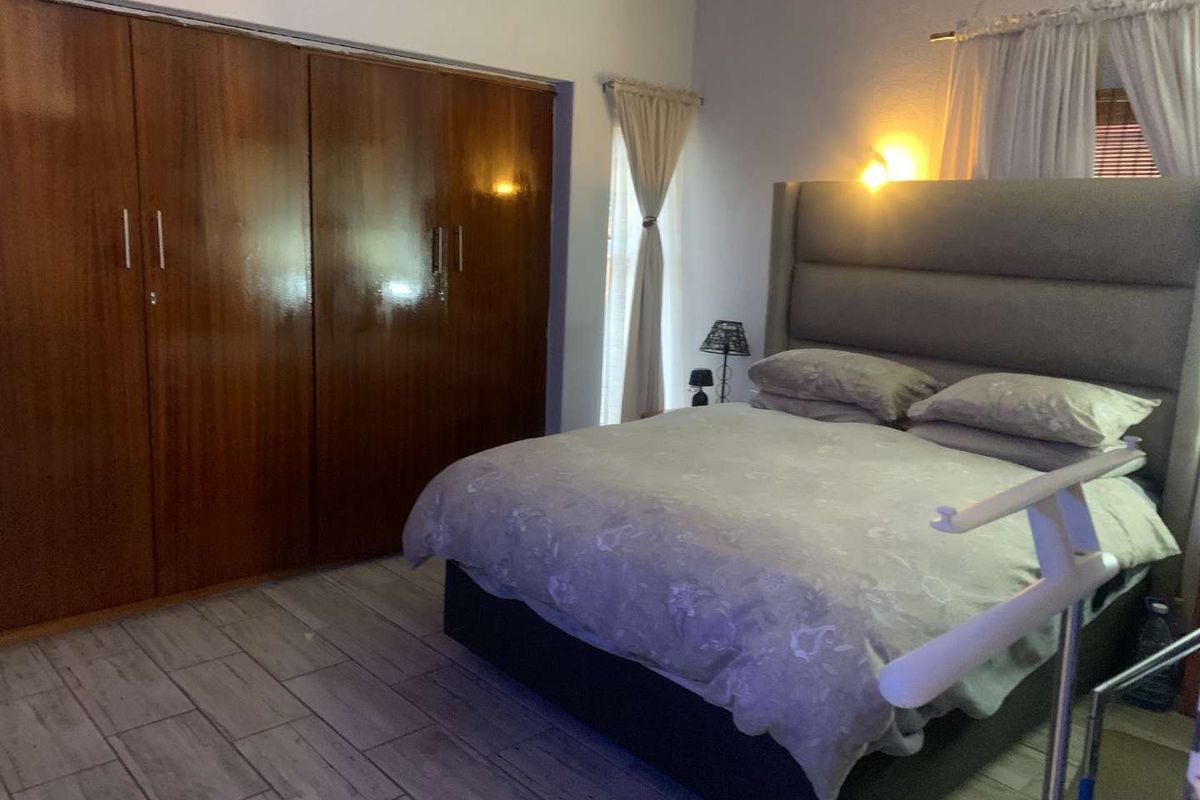 A bedroom featuring built-in wooden cupboards and tiled flooring, providing functional storage and a neutral base for interior design.