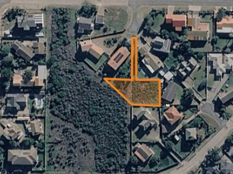 Aerial view of a vacant residential plot highlighting the property boundaries within an established suburban neighborhood.