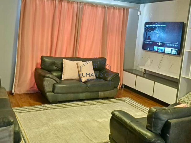A living room featuring laminate flooring and a built-in media console unit.