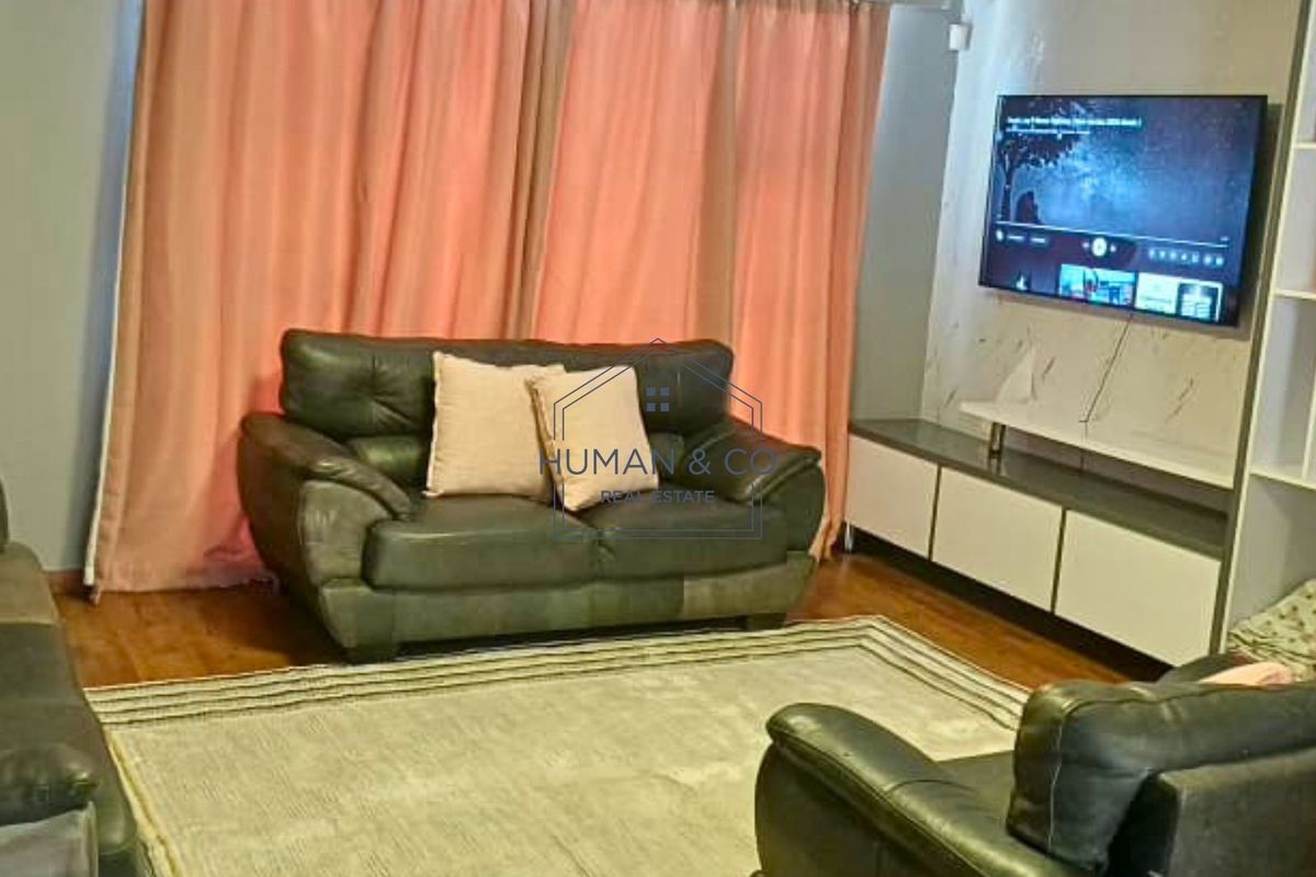 A living room featuring laminate flooring and a built-in media console unit.