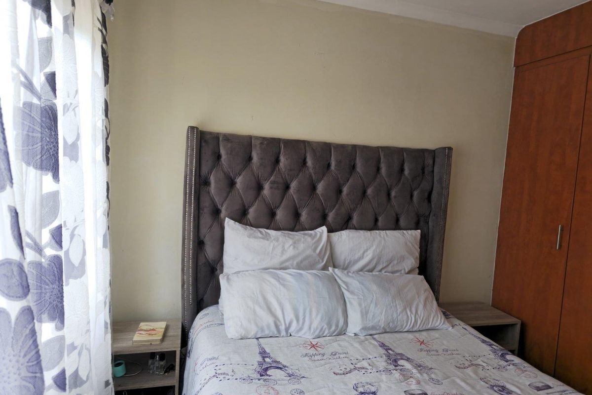 A bedroom featuring built-in wooden cabinetry and neutral wall finishes, providing a functional and comfortable sleeping space.