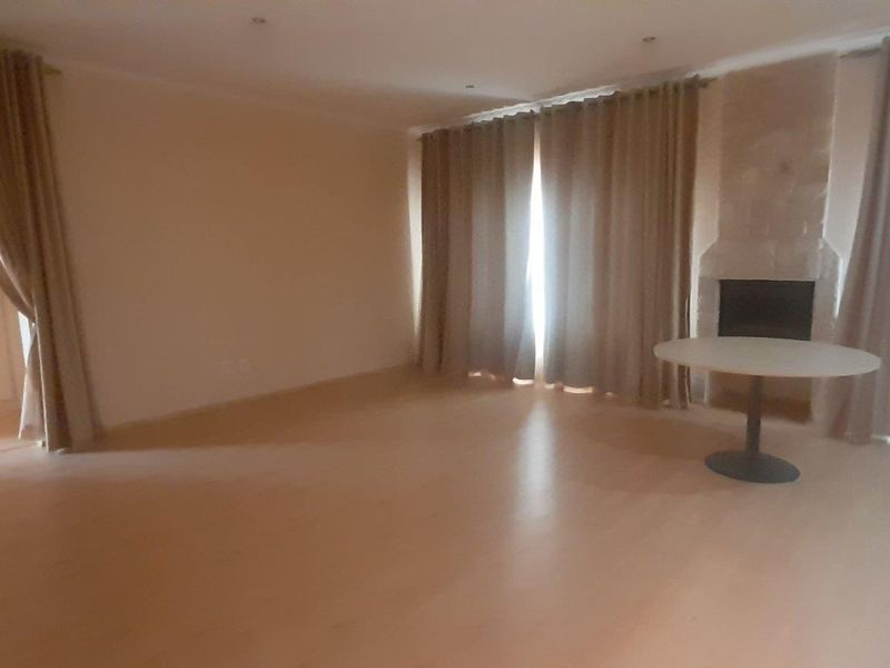 Spacious living room featuring laminate flooring, recessed lighting, and a built-in fireplace, offering a blank canvas for interior design.