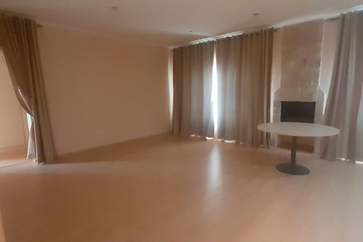Spacious living room featuring laminate flooring, recessed lighting, and a built-in fireplace, offering a blank canvas for interior design.