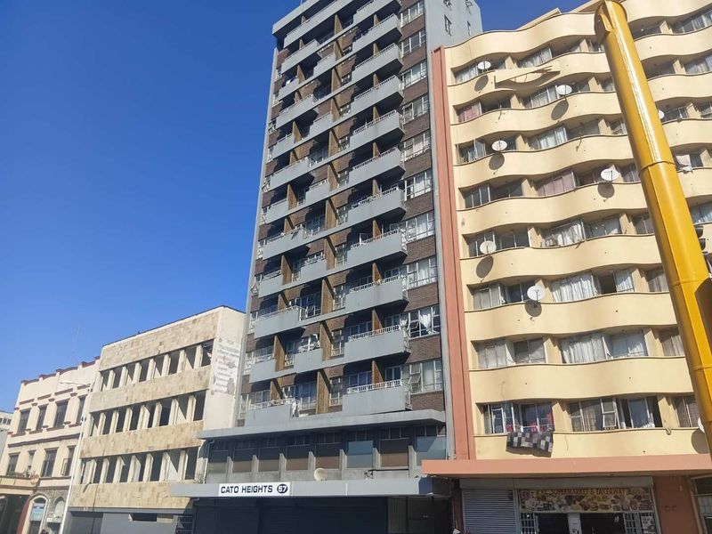 Exterior view of Cato Heights apartment building featuring multiple levels with private balconies and ground floor commercial space.