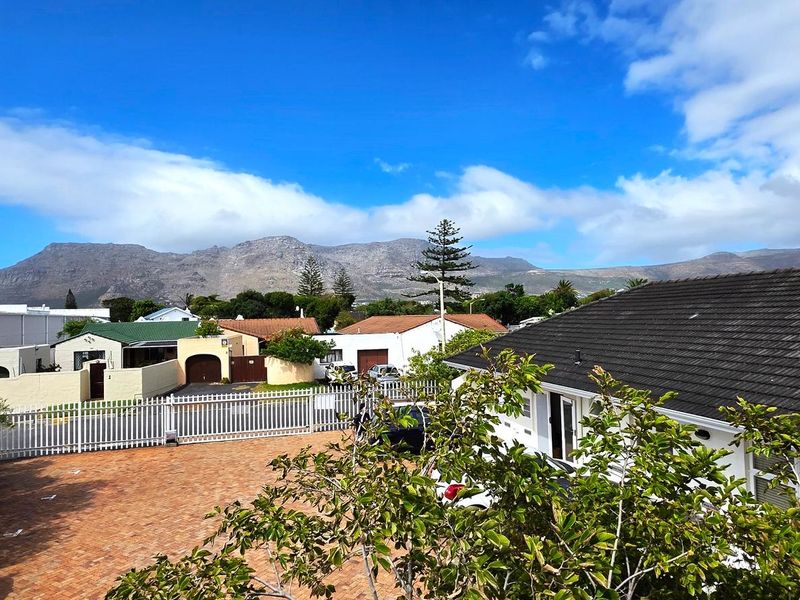 Elevated view overlooking the property grounds, surrounding neighbourhood, and scenic mountain range in the distance.