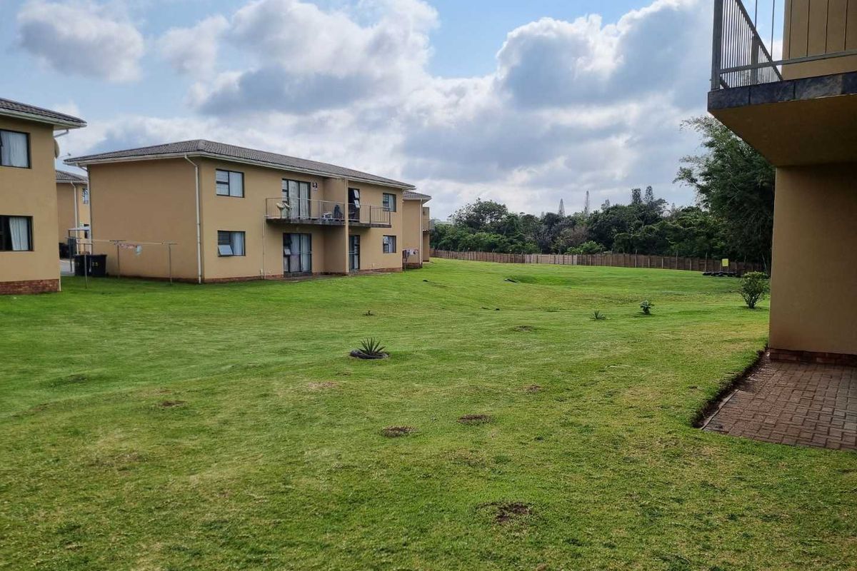 View of the communal garden area and exterior building facades within the apartment complex.