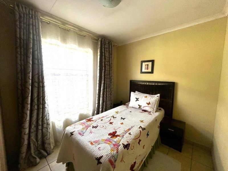 A standard bedroom featuring tiled flooring and coved ceiling details, providing a functional and neutral living space.