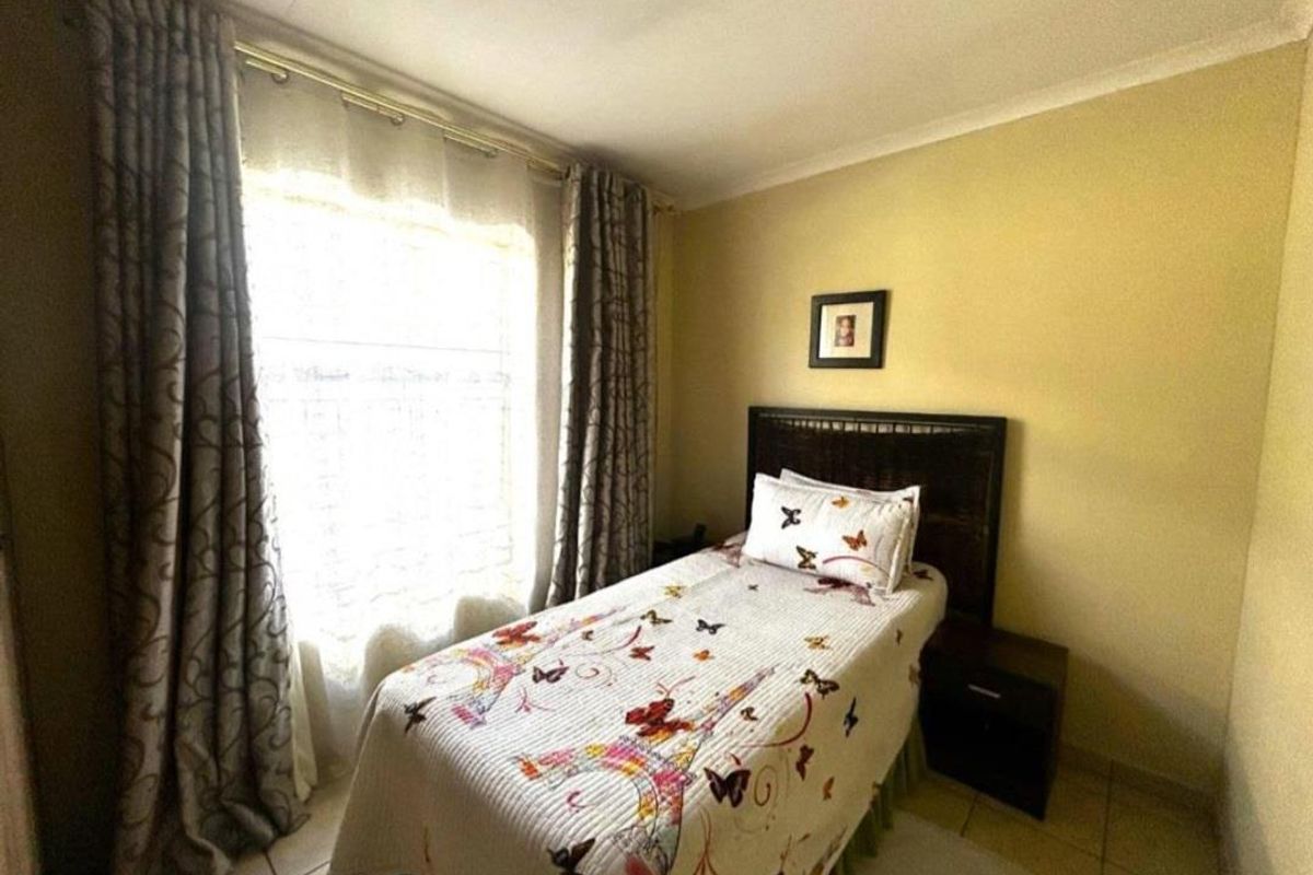 A standard bedroom featuring tiled flooring and coved ceiling details, providing a functional and neutral living space.