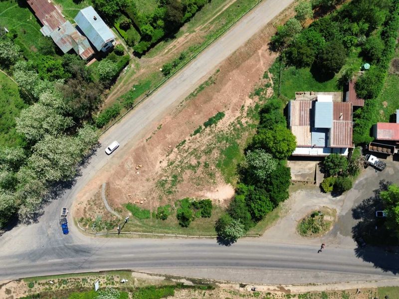 Aerial view of a vacant commercial land parcel featuring road frontage and established surrounding vegetation.