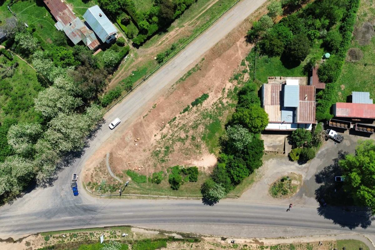 Aerial view of a vacant commercial land parcel featuring road frontage and established surrounding vegetation.