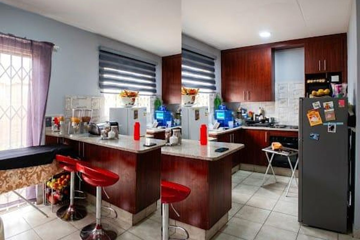 A functional kitchen featuring dark wood cabinetry, granite countertops, built-in oven and hob, and tiled flooring with direct access to an outdoor area.