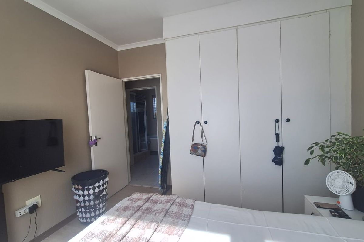 A bedroom featuring built-in cupboards and direct access to an adjoining bathroom.
