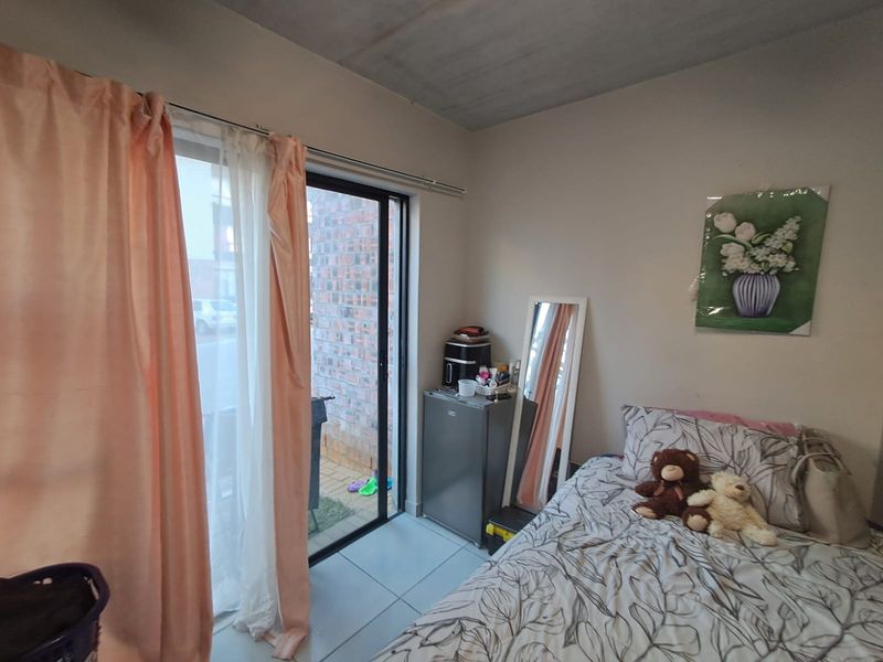 A bedroom featuring tiled flooring and a sliding glass door providing access to an outdoor area.