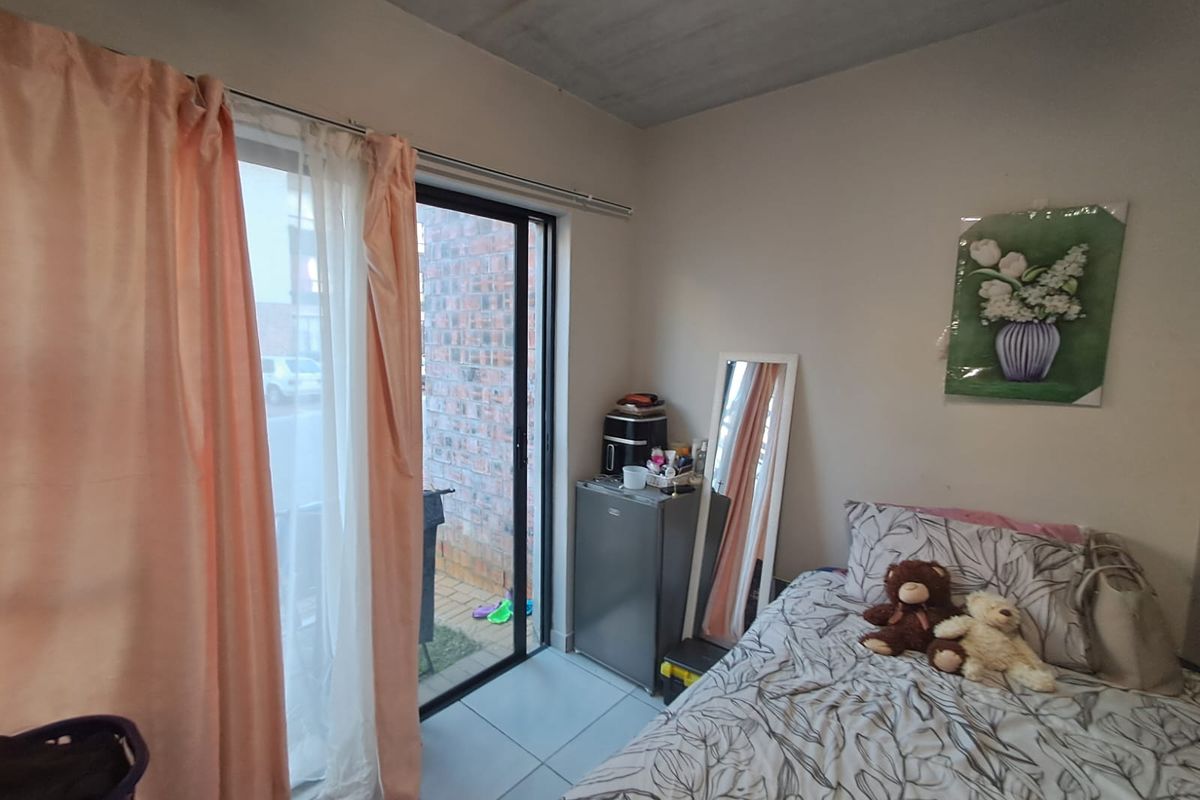 A bedroom featuring tiled flooring and a sliding glass door providing access to an outdoor area.