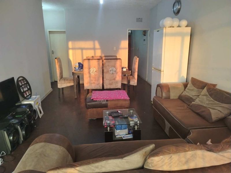 An open-plan living and dining area featuring tiled flooring and direct access to adjacent rooms.