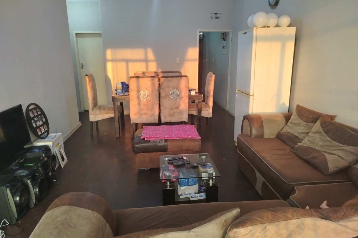 An open-plan living and dining area featuring tiled flooring and direct access to adjacent rooms.