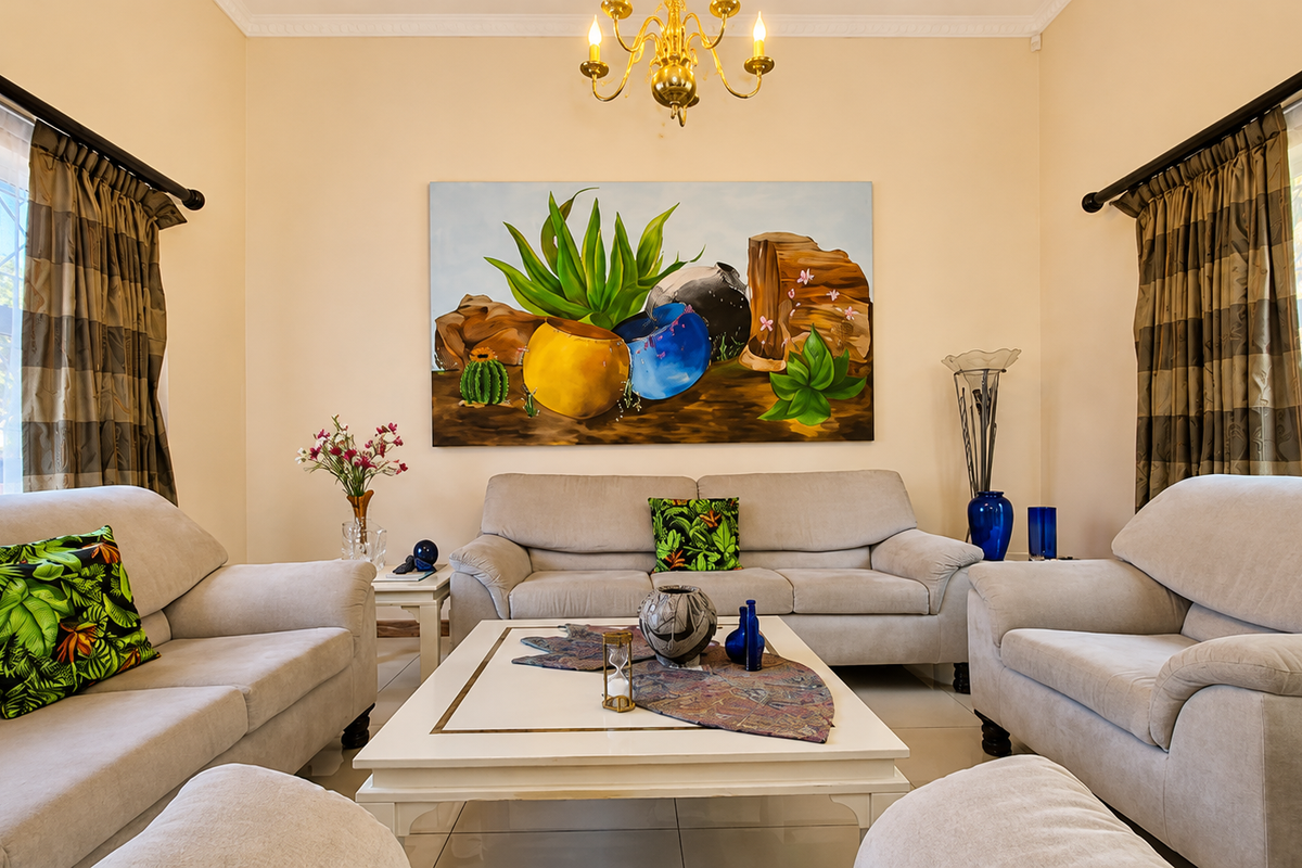 A well-maintained living room featuring tiled flooring, decorative coving, and a classic brass chandelier, creating a warm and inviting atmosphere.
