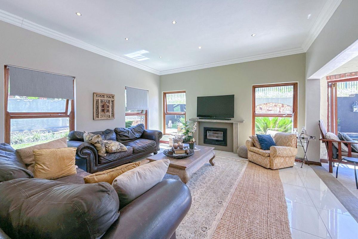 Spacious living room featuring a built-in fireplace, tiled flooring, recessed ceiling lighting, and large windows providing ample natural light.