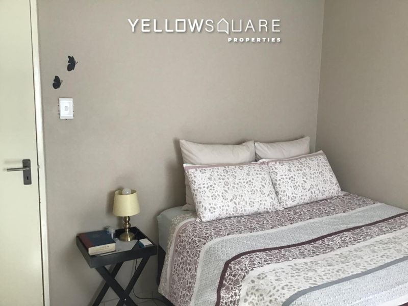 A simple bedroom featuring neutral wall tones and a standard door, providing a functional space for rest.