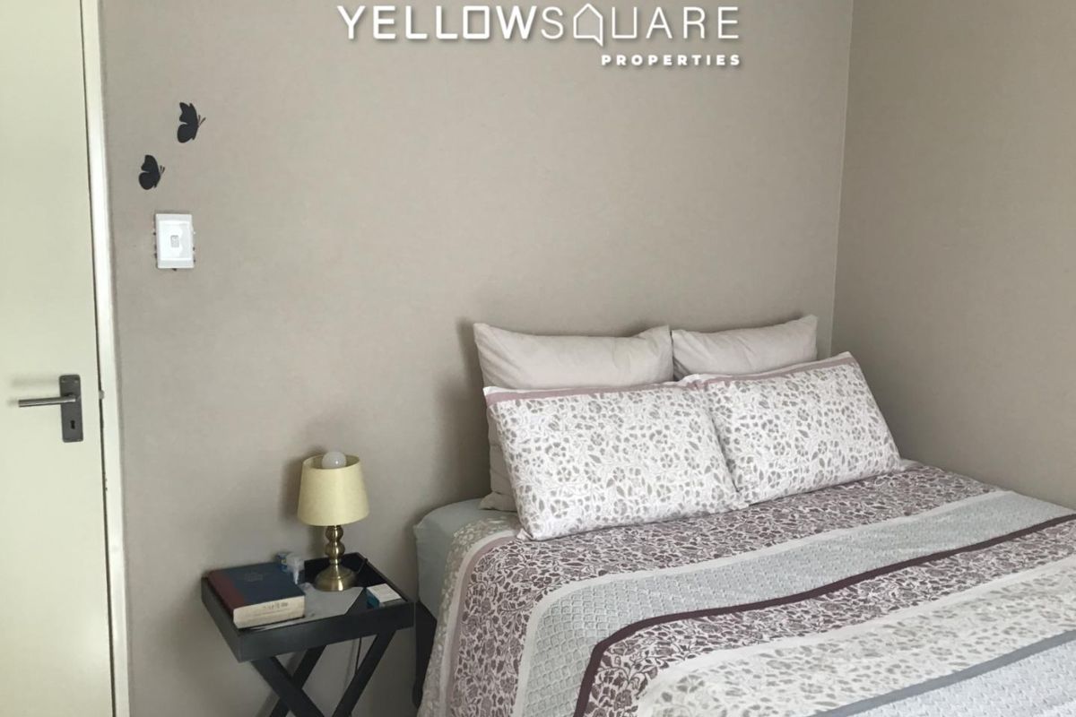 A simple bedroom featuring neutral wall tones and a standard door, providing a functional space for rest.
