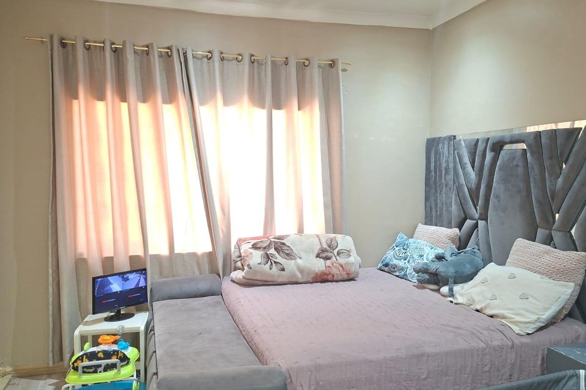 A bedroom featuring a built-in wardrobe and neutral wall finishes, providing a functional space for rest.