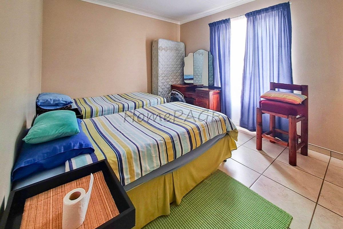 A bedroom featuring tiled flooring and a window with curtain tracks.