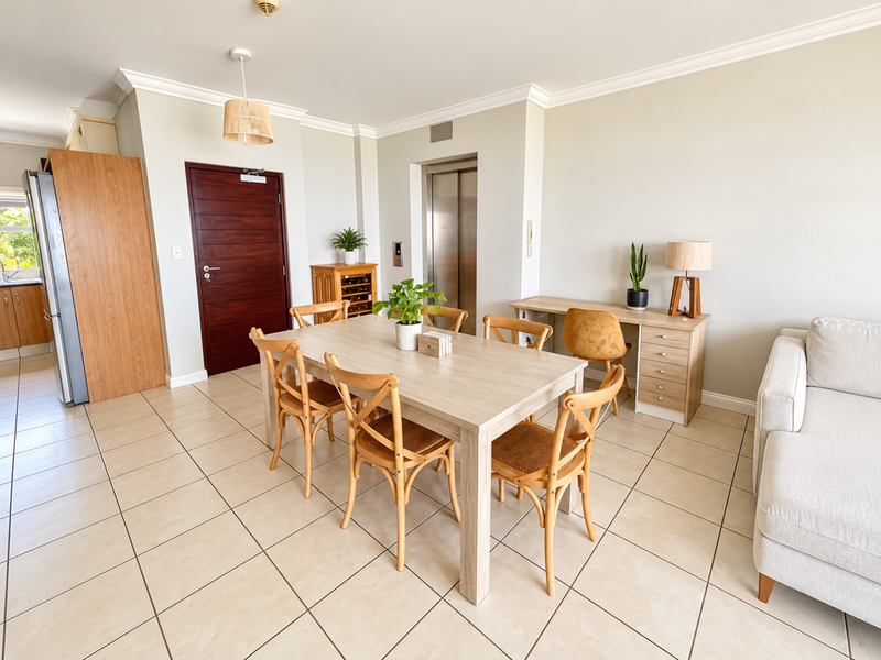 Spacious open-plan living and dining area featuring tiled flooring, crown molding, and convenient direct elevator access.