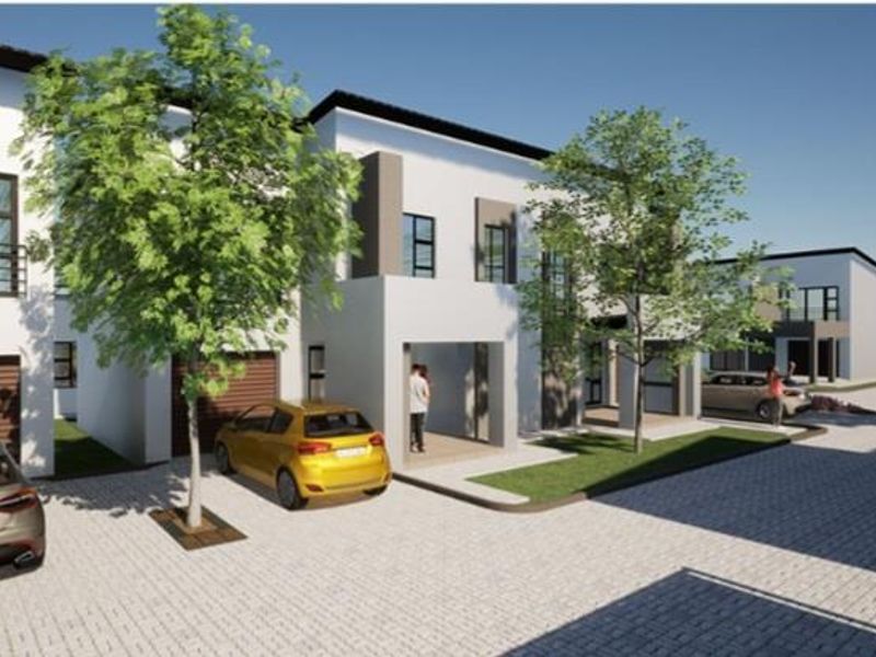 A modern residential townhouse complex featuring clean architectural lines, paved driveways, and integrated garage access.