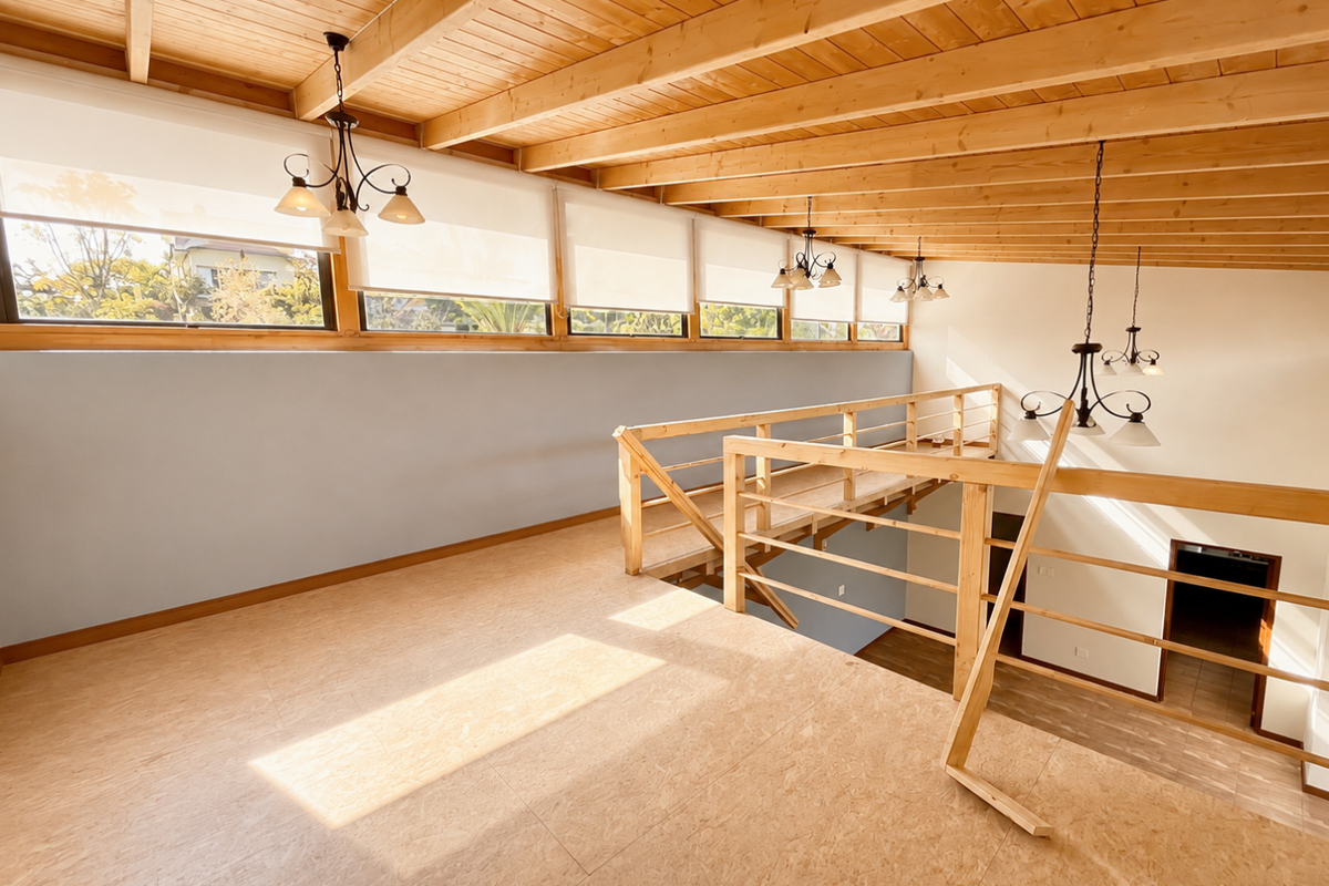 Spacious mezzanine living area featuring exposed timber beam ceilings, natural light, and a timber staircase overlooking the lower level.